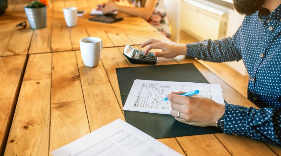 male-adviser-filling-in-tax-documents-in-office-2021-09-01-05-18-50-utc (1) (1)