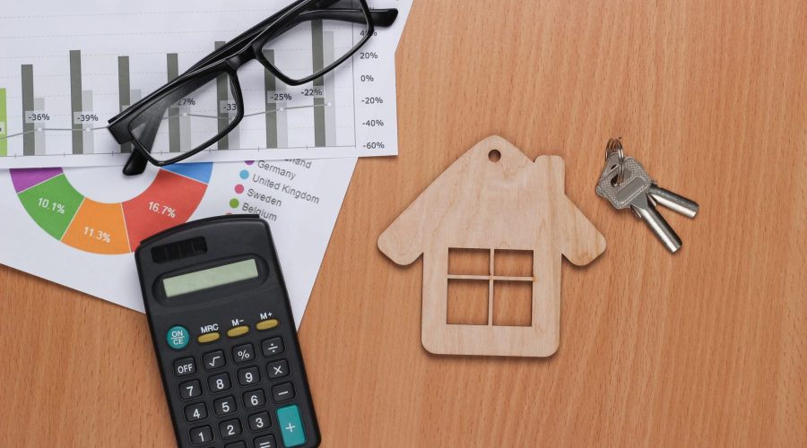 Profitable investment. Market analysis. Buying a property. House Minifigure,  graphs and chartsc, calculator on desk. Top view