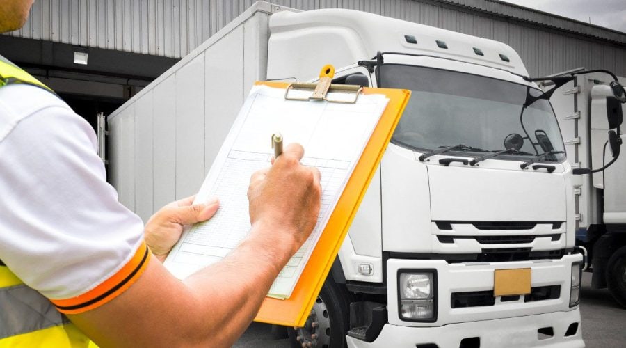 transportistas-anotando-datos-frente-a-un-camion