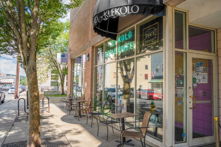 Klekolo World Coffee storefront in Middletown, CT with outdoor seating under tree-lined sidewalk