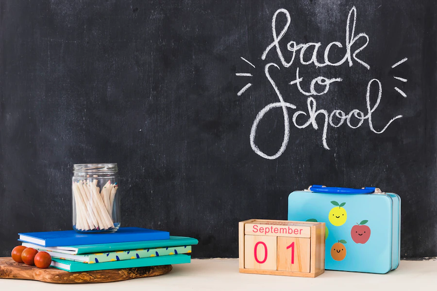 stationery-calendar-lying-near-lunchbox-blackboard_23-2147866258
