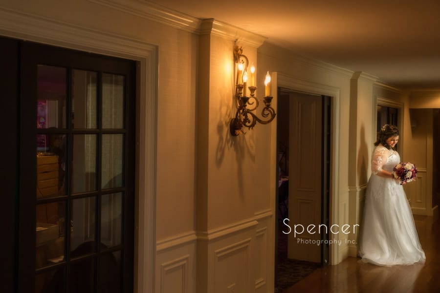 bride posing in hallway of shady hollow country club