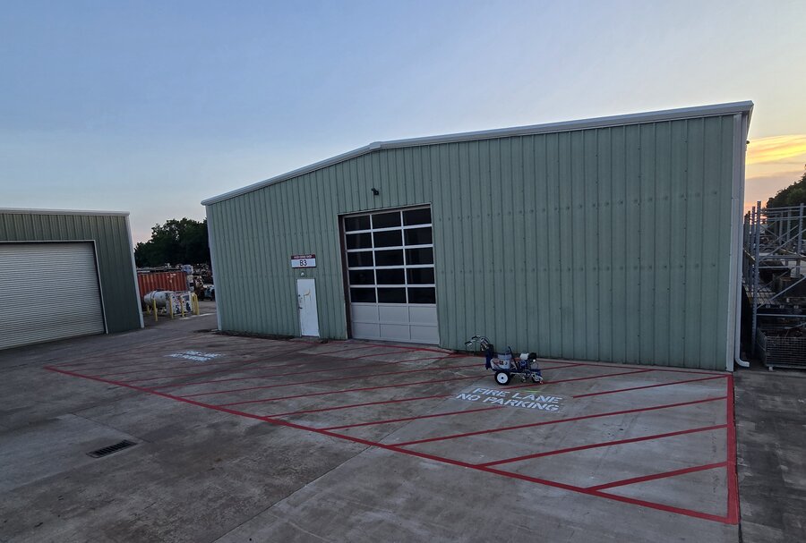 Warehouse exterior with fresh red fire lane striping before completion