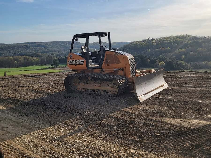 Land Clearing in Jamestown, NY Crawler dozer working cleared ground at dusk with a tree line on the horizon