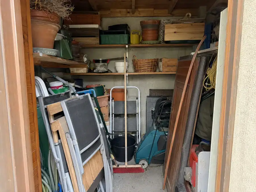 Remise encombrée d’outils de jardin avant enlèvement