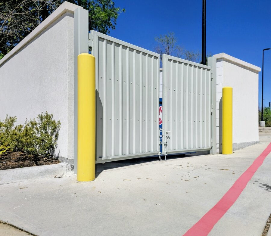 Yellow-painted parking bollards at a commercial property in North Houston