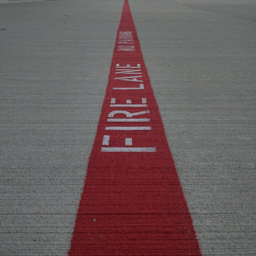 TOW AWAY ZONE and fire lane pavement markings on commercial asphalt