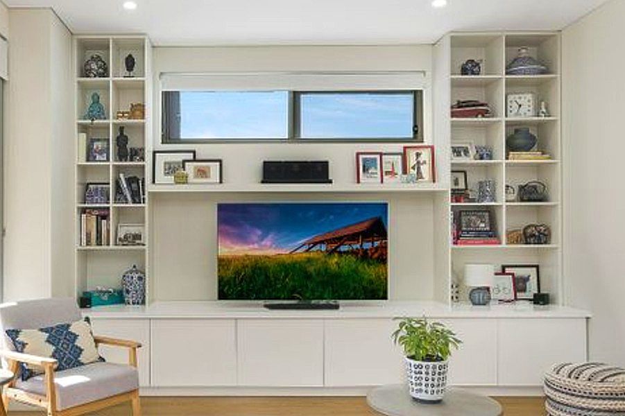 Custom-made Entertainment unit with free floated shelf and bookcase on each side. This unit has solid close push touch doors and is finished in the white satin ploy. Custom-made joinery and cabinet making.