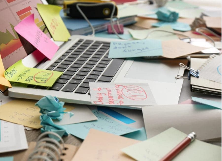 Laptop mit Post-its, zerknüllte Zettel