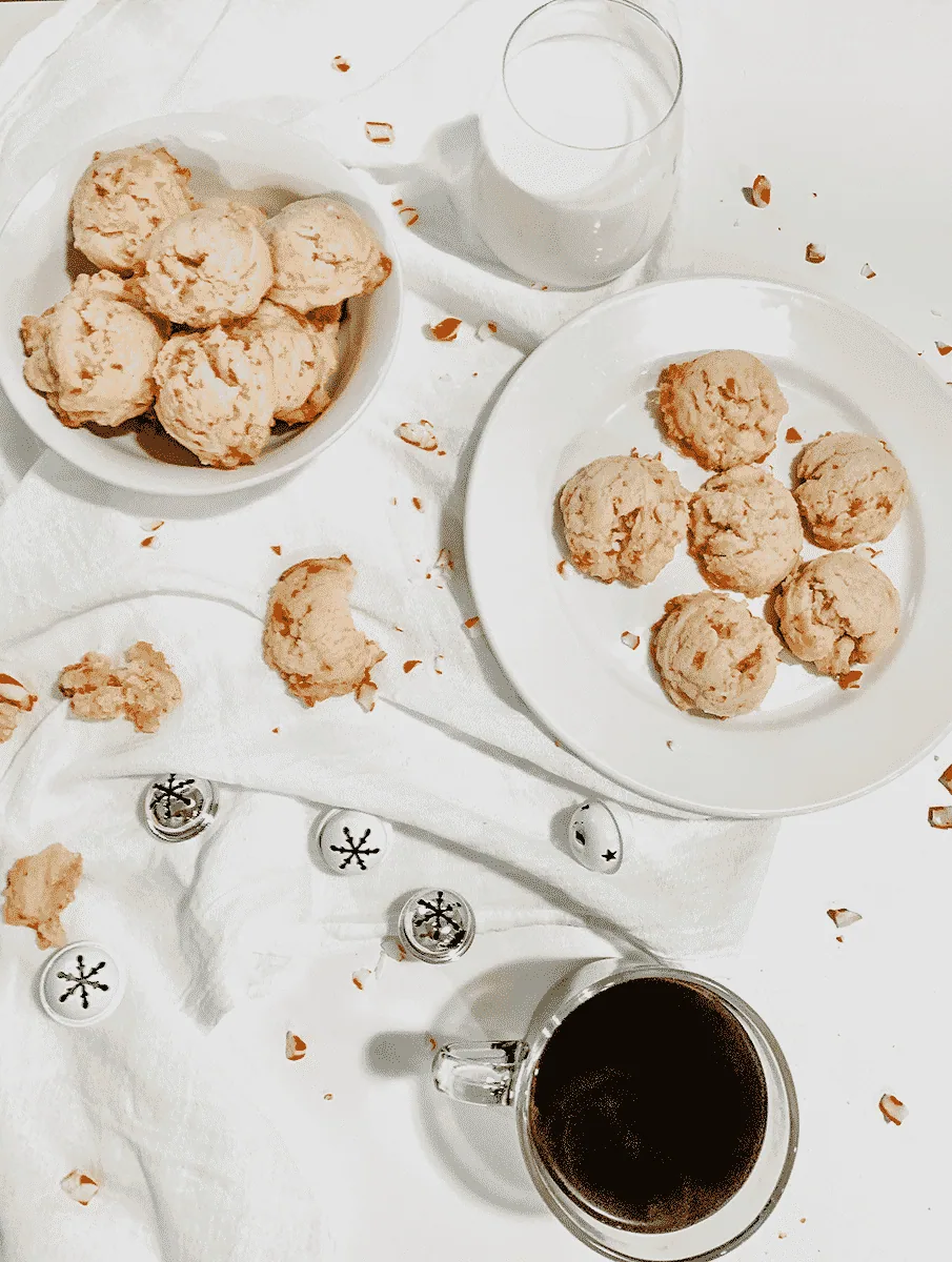 cookies on a white napkin and more cookies broken on the side, milk and coffee in glasses