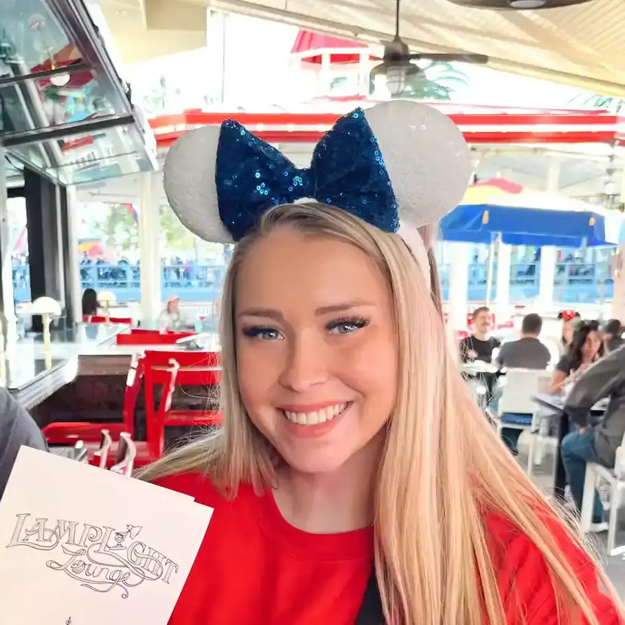 Minnie Mouse ear headband at Disneyland, smiling woman at Disney park.