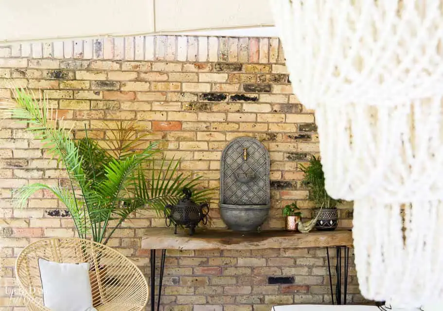 Covered Outdoor Living are close up of brick wall with fountain and palm tree