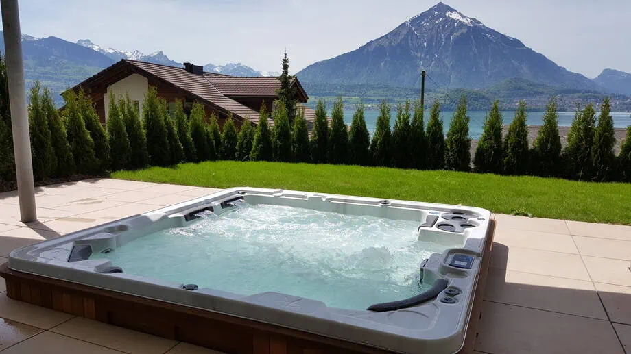Un spa encastré dans une terrasse bénéficie d'une belle vue sur les montagnes. 