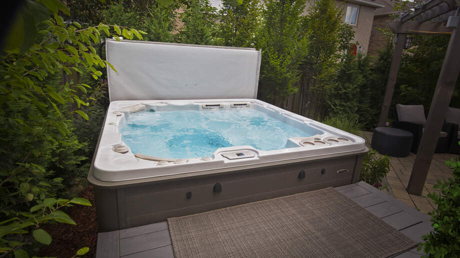Un spa dont la couverture a été retirée dévoile une eau cristalline et propre. 