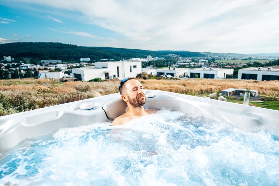 Un homme est installé dans un spa et profite des jets hydromassants qui procurent des massages relaxants et thérapeutiques. 