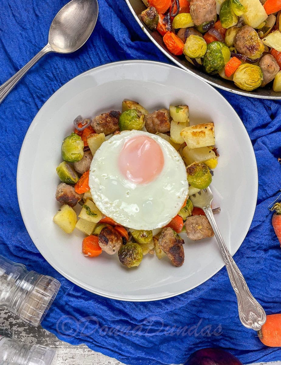 served portion of sausage breakfast hash with a fried egg.