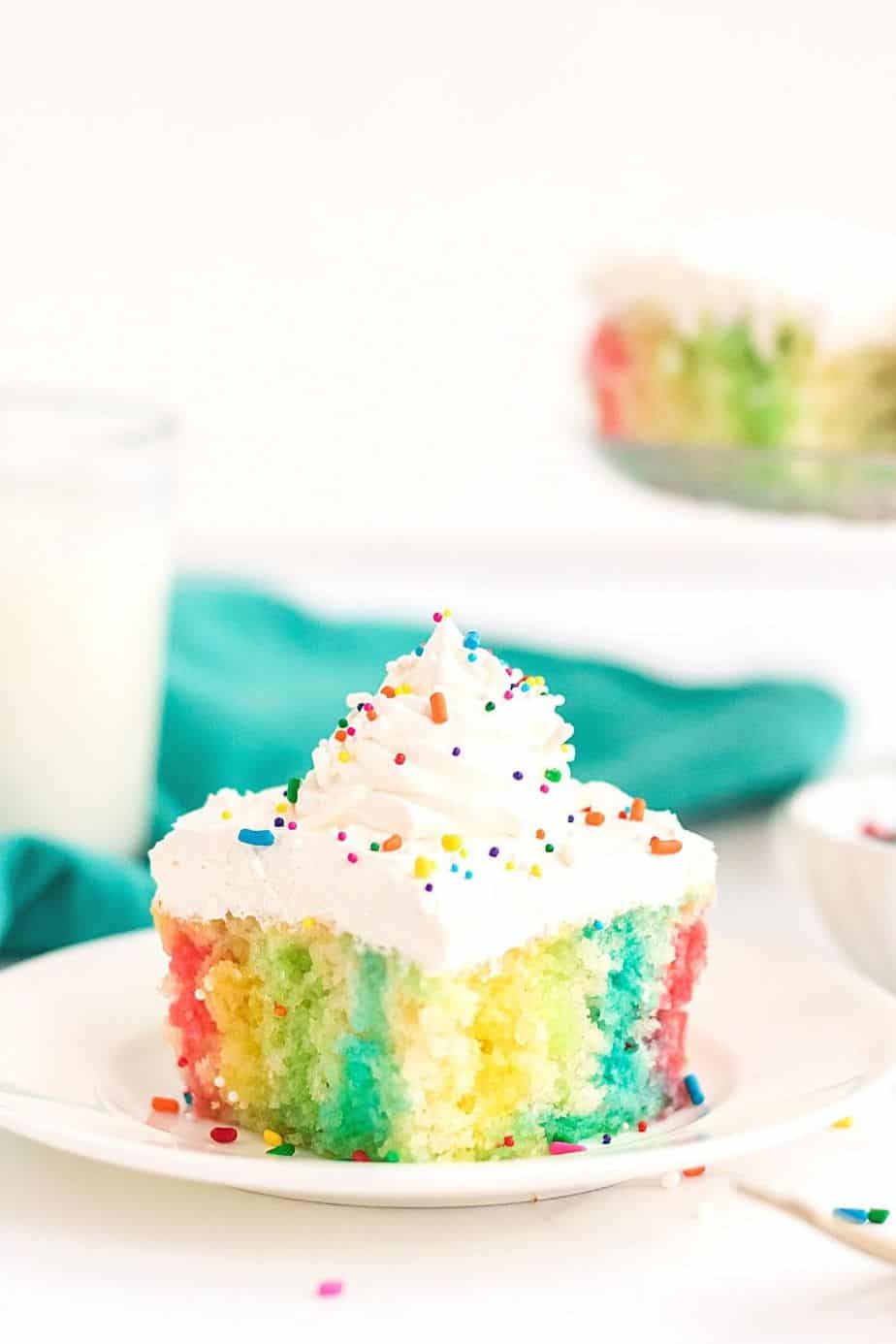 Make a colorful, moist, and utterly delicious cake within minutes with this Rainbow Poke Cake recipe. It is full of flavor and plenty of fun colors, including shades of pink, blue, and yellow!