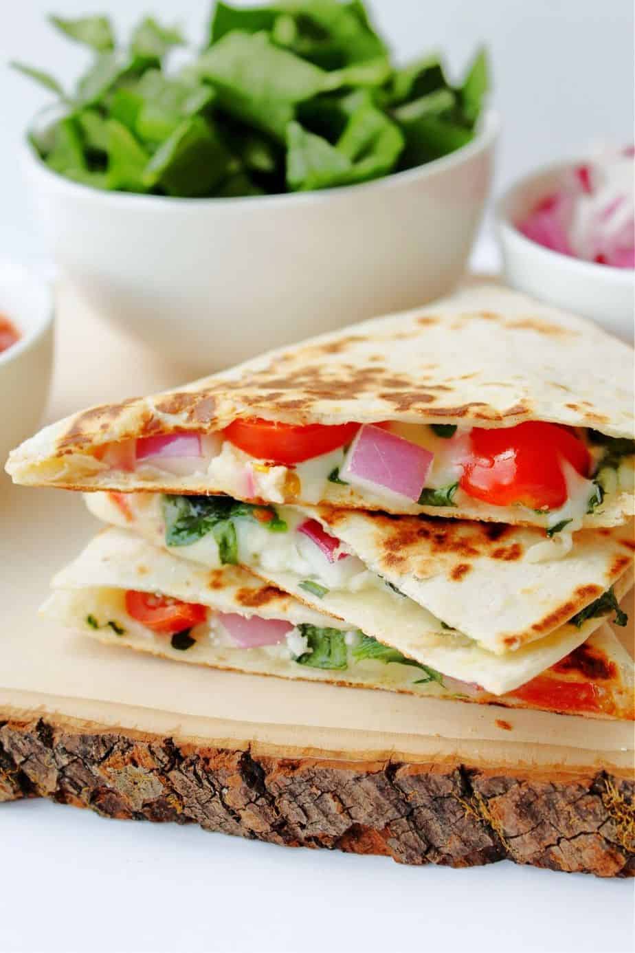 Use this Mediterranean Quesadillas recipe to prepare a cheesy meat-free meal full of fresh vegetables. These quesadillas are perfect to eat for breakfast, lunch, or dinner! This easy quesadilla recipe is a delicious meatless meal idea. It's a perfect sandwich recipe for lunch or dinner.