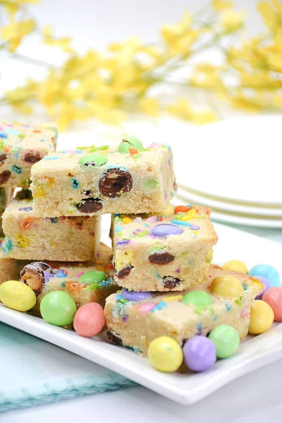 Make fun and flavorful Easter Cookie Bars for the holiday. These easy cookie bars are sure to be a huge hit for your Easter celebration. These thick and chewy M&M Cookies bars are perfect for any holiday or occasion. Fill them with chocolate chips, M&M's, or any chopped chocolate candy. They're also perfect to use up leftover Halloween candy.