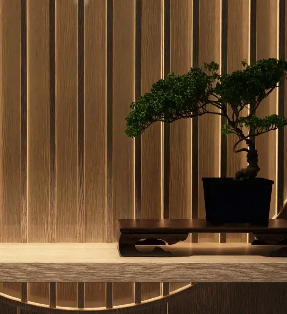 Modern hotel interior featuring a bonsai tree on a wooden console against a warm wood-paneled wall with integrated lighting.