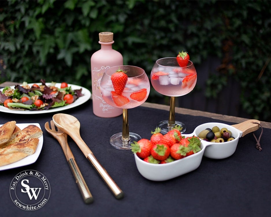 5 pieces from Elys Wimbledon Homeware to create a sophisticated summer table. Gold stemmed gin and tonic glasses, handled server, gold salad servers and navy tablecloth. 