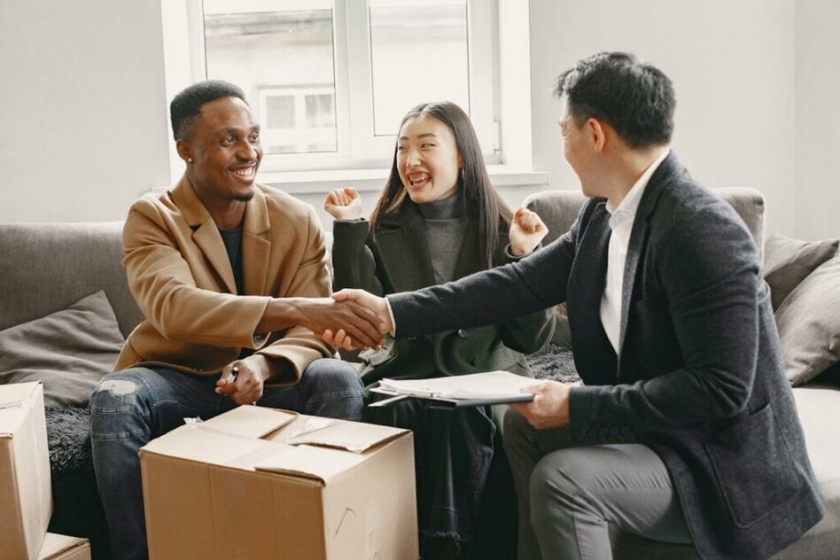 A Couple Happily Talking to a Realtor and Shaking Hands