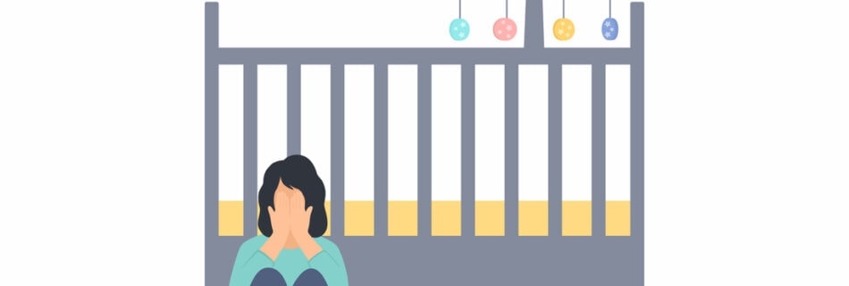 Woman crying next to empty crib following infant or pregnancy loss. Therapy for perinatal mental health, reproductive trauma, and loss in NYC and Denver supports you in healing.
