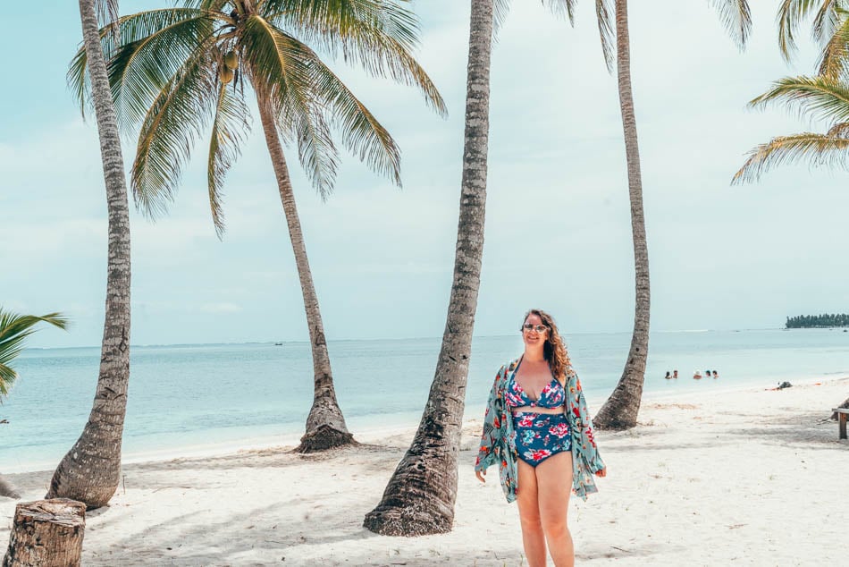 Curvy girl in a swimsuit amidst palm trees on an island in San Blas Panama