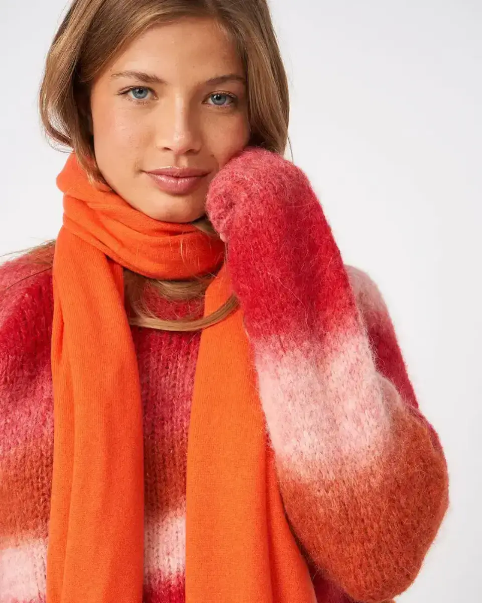 Modelo con jersey de punto multicolor y bufanda naranja de Les Tricots de Léa. Colección de knitwear francés disponible en nuestro showroom de Madrid.