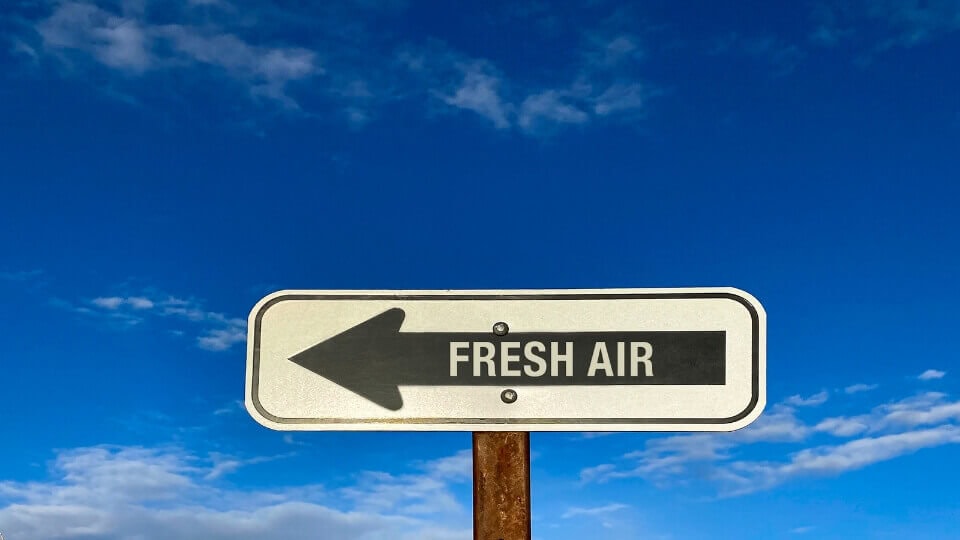 A sign that says fresh air in the middle of a country road