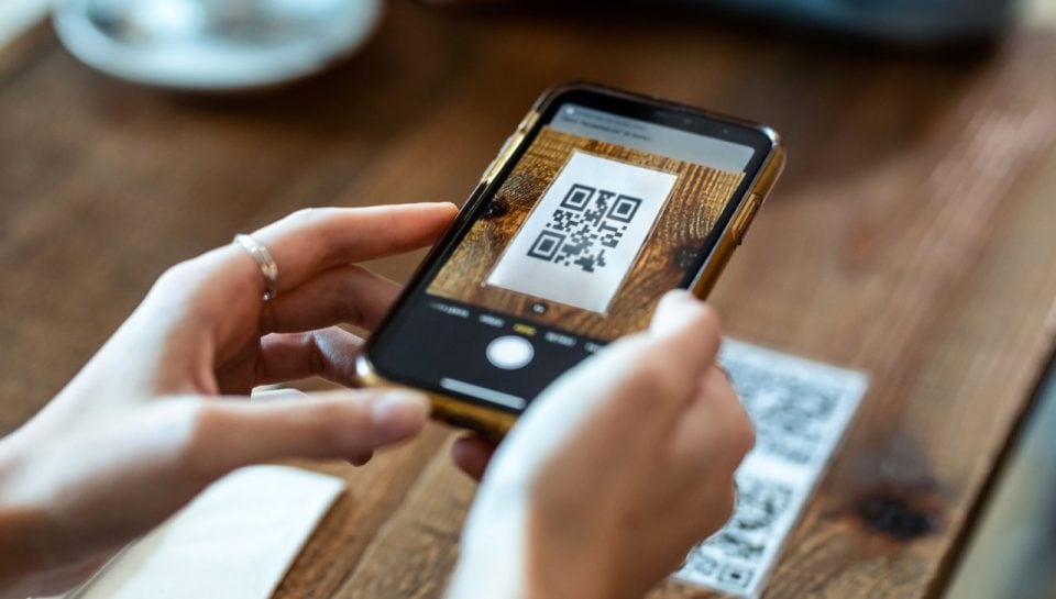 woman-hands-using-the-smart-phone-to-scan-the-qr-c-2024-09-12-14-22-08-utc Persona escaneando un código QR con un teléfono móvil.