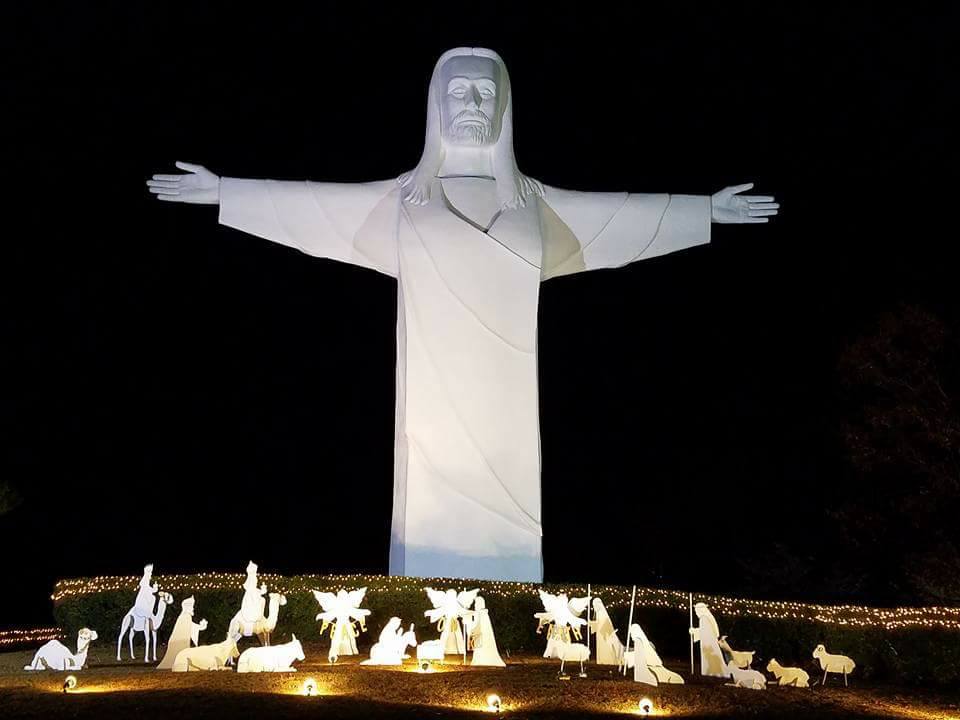 A towering illuminated Christ the Redeemer statue at night in Eureka Springs, Arkansas.