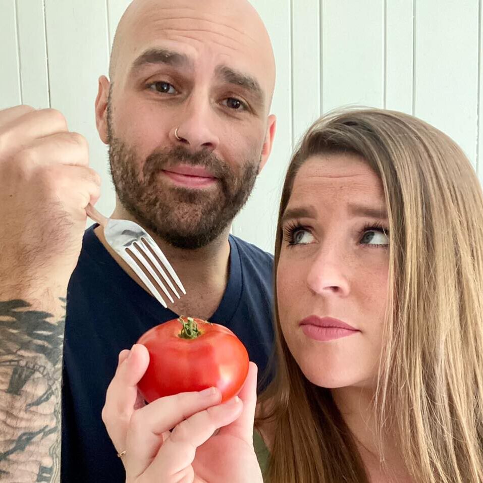 Profile Pic The two members of Hangry in Love. Zach holding a fork over a tomato that Sarah is holding