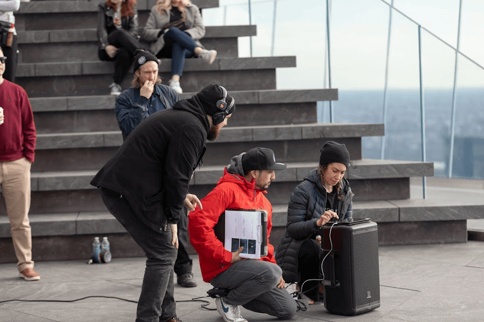 An image of a videomakers crew working with a sound speaker while filming a video