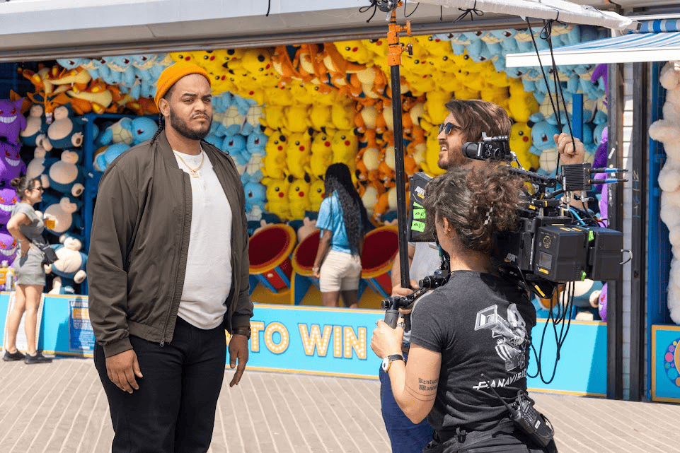 An image of a camerawoman filming a man in a theme park