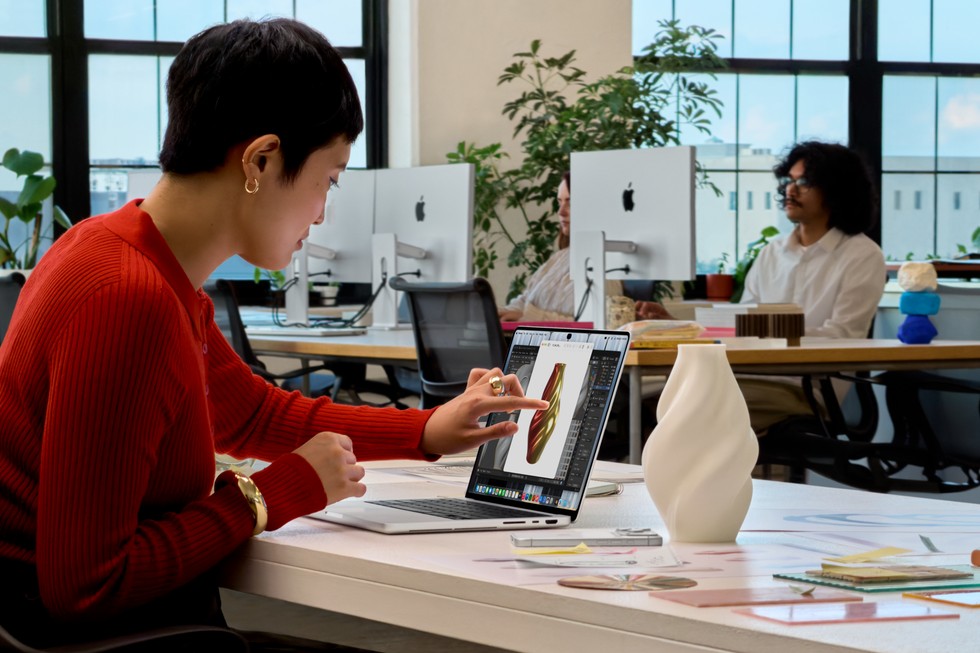 Pessoa trabalhando no novo MacBook Pro numa mesa de escritório