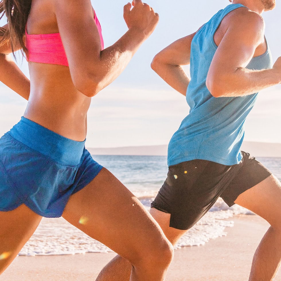 People running along a sandy beach, staying active and supporting overall wellness and fitness with vitamin injections at BionwoRx in Carmel, Indiana.