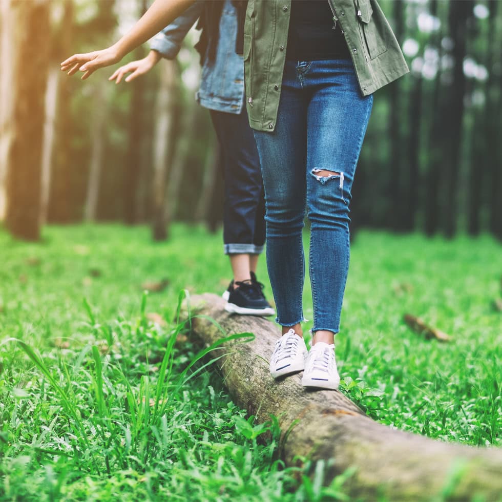 Two people walking through wooded trails in Indiana, highlighting Lyme disease risk and prevention near Carmel for BionwoRx patients