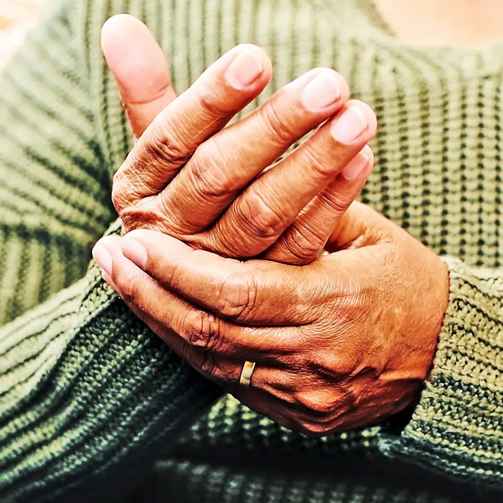 Senior experiencing relief from hand joint pain after regenerative A2M therapy