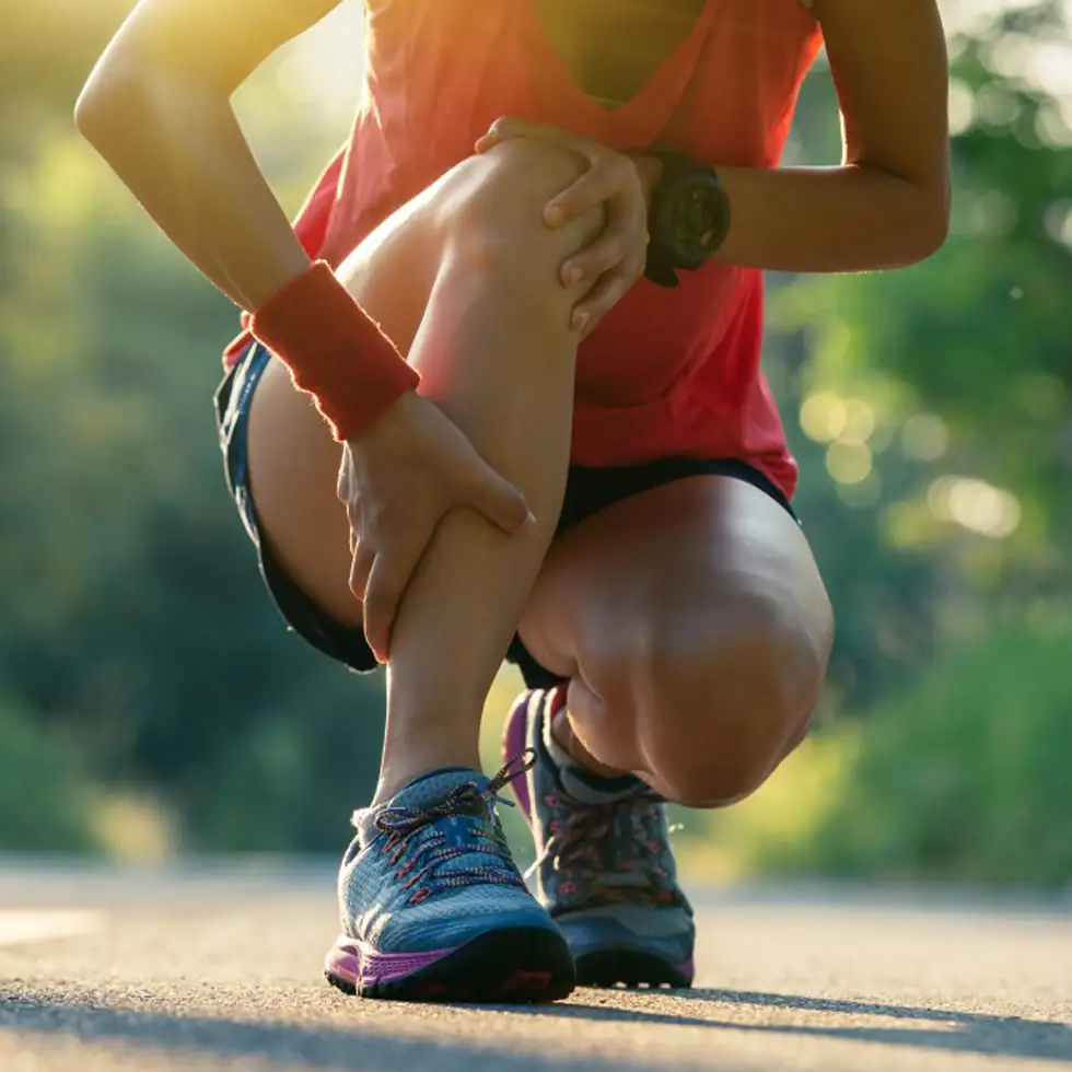 Woman holding her knee in pain before receiving Photobiomodulation Therapy (PBMT) at BionwoRx Center for Functional and Regenerative Medicine in Carmel, Indiana, for inflammation and joint recovery.