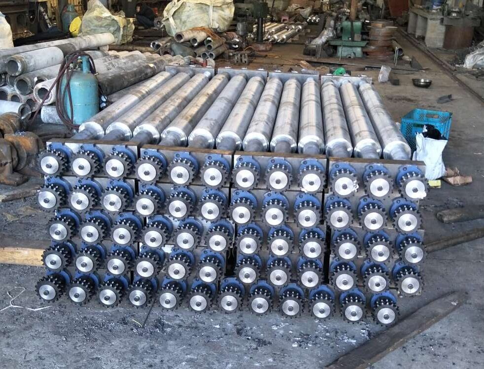 Straight radiant tubes stacked in the factory with circular end openings visible