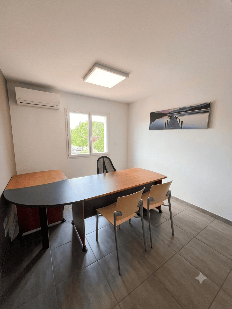 Location bureau professionnel climatisé et lumineux avec grand bureau d'angle en bois et chaises grises.