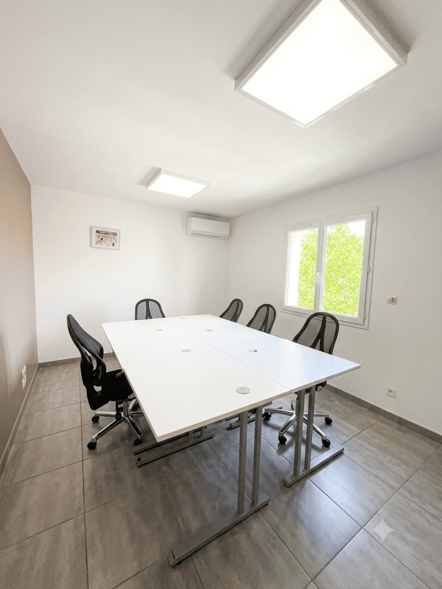 Grande salle de réunion moderne à louer avec table modulaire blanche et chaises de bureau ergonomiques.