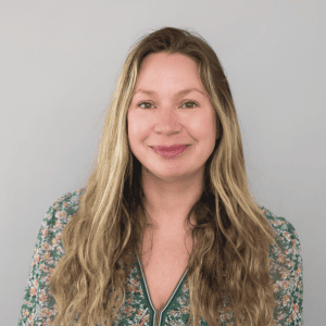 Portrait of Allison Malinowski smiling with long wavy hair.