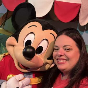 407vacations.com, Disney character Mickey Mouse with woman at Orlando theme park, family-friendly vacation, Orlando vacation rental, Orlando theme park fun.