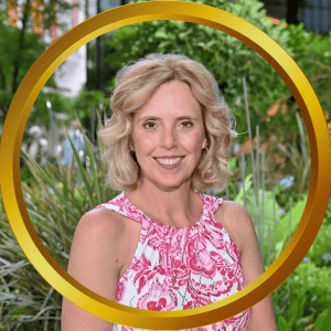 Portrait of Carla Williams smiling outdoors in a garden setting.