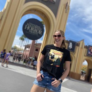 Vibrant woman at Universal Studios Orlando in front of the iconic park entrance.