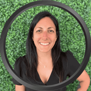 Portrait of Stephanie Romanelli with green background and black top.