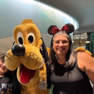 Family enjoying a fun Disney character encounter with Pluto at the theme park.