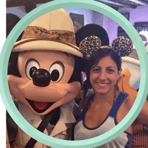 Mickey Mouse with a woman wearing leopard print Minnie ears at a Disney destination.